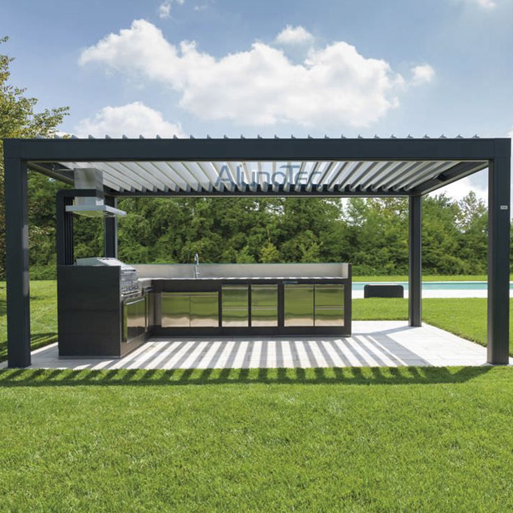 an outdoor kitchen is shown in the middle of a grassy area with a grill on it