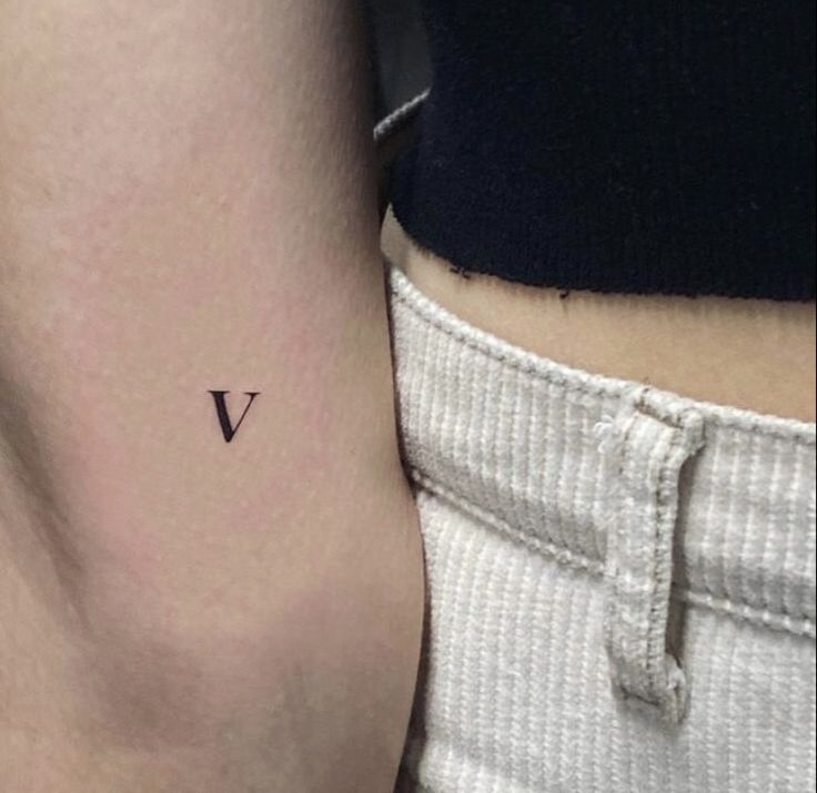 a small v tattoo on the left thigh