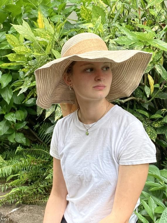 Floppy straw beach hat with natural linen ribbon and bow.Summer straw hat is perfect for wearing to the beach, a picnic, out and about in town on a warm, sunny day!Natural linen bowGrosgrain ribbon interior headband Brim size - 5 1/4”Full diameter - 18”Head size - 21”Wire in brim edge for shaping Sun n’ Sand HeadwearCondition is very good. Bohemian Natural Panama Hat For Garden Party, Lightweight Natural Straw Hat For Sunbathing, Casual Toquilla Straw Sun Hat For Sunbathing, Beige Beachy Straw Hat For Beach, Beige Straw Sun Hat For Sunbathing, Lightweight Beachy Straw Hat For Sunbathing, Beige Sun Straw Hat For Sunbathing, Beige Sun Straw Hat For The Beach, Beige Summer Straw Hat For Vacation