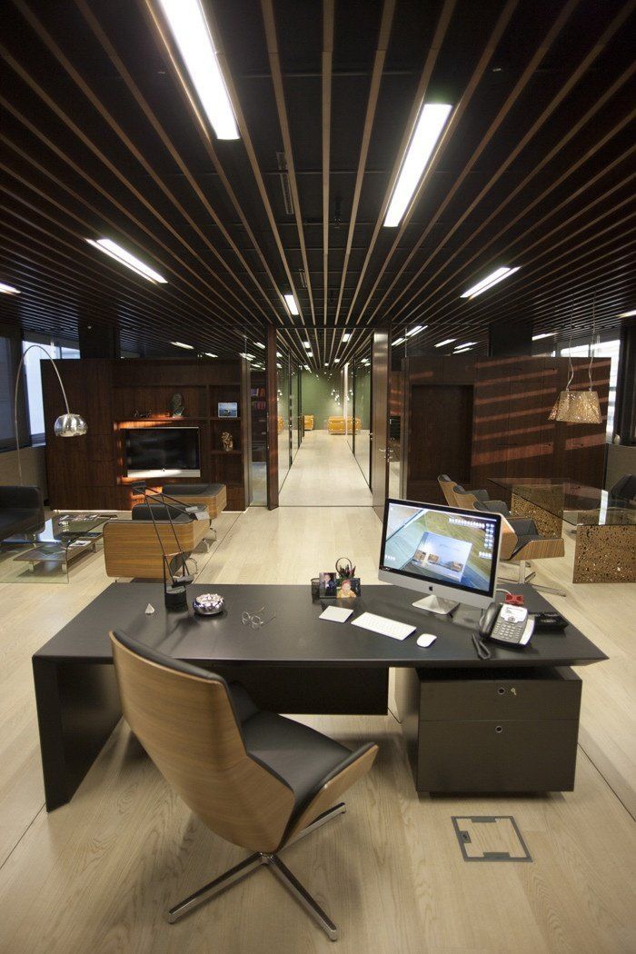 a desk with a computer on top of it in a room filled with wooden floors