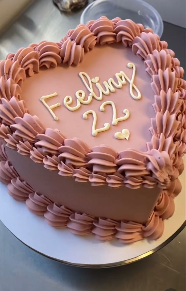 a heart shaped cake with the words feeling 22 on it's frosting and pink icing