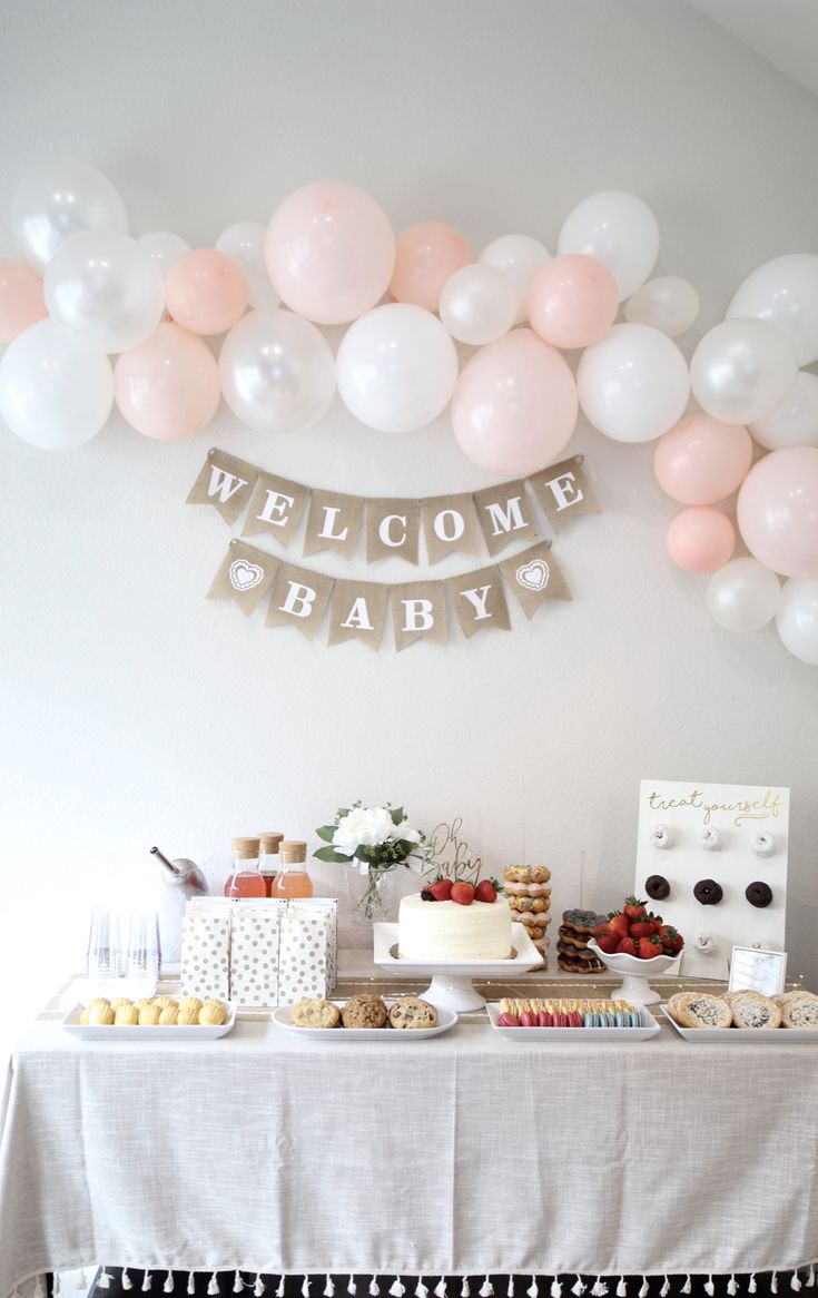 a welcome baby party with balloons and desserts