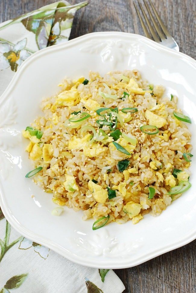 a white plate topped with fried rice and vegetables