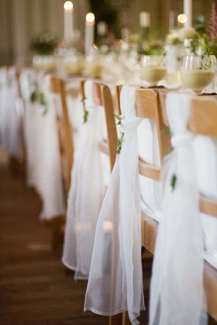 the table is set with white cloths and flowers