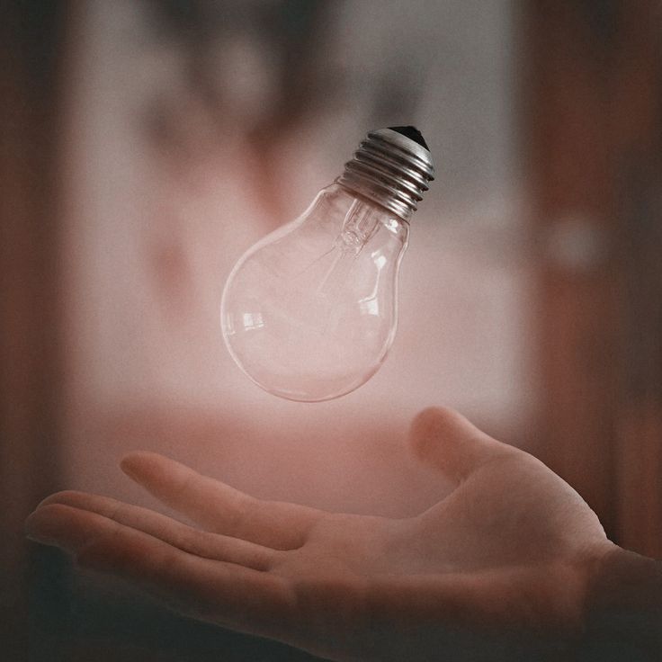 a light bulb in the palm of someone's hand