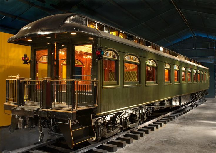 a green train car sitting inside of a building