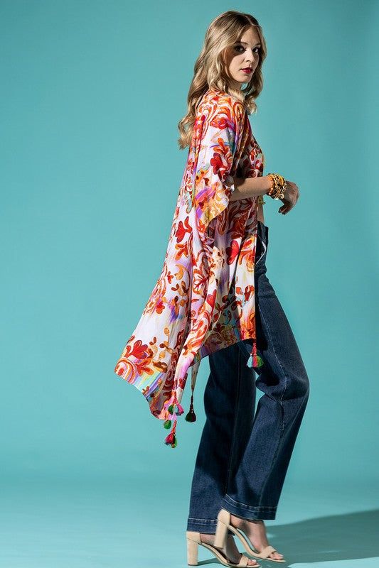 The bohemian wardrobe staple every woman needs! This stunning intricate bohemian print kimono features breezy side slits, half-length kimono sleeves, and a relaxed oversize fit. Throw it on at the beach for a quick cover-up or style it with your favorite jeans and a band tee for a cool everyday look. The gorgeous multicolor print will have you turning heads wherever you go! 100% Viscose Relaxed Oversized Fit Mid-length Side Slits Open Front Bohemian Style Length: 38" Width: 40" One size fits most Bohemian Kimono With Boho Print For Beach Cover-up, Bohemian Multicolor Tassel Cover-up, Bohemian V-neck Kaftan For Spring, Boho Print Cover-up With Kimono Sleeves For Beach Season, Open Front Beach Kimono With Tassels, Oversized Spring Tunic Cover-up, Long Tasseled Kimono For Beach Cover-up, Long Tasseled Kimono For Vacation, Hippie Printed Kimono For Beach Cover-up