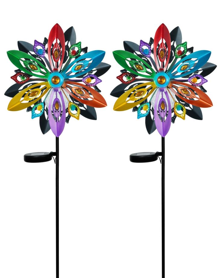 two colorful metal flower sculptures on black stands