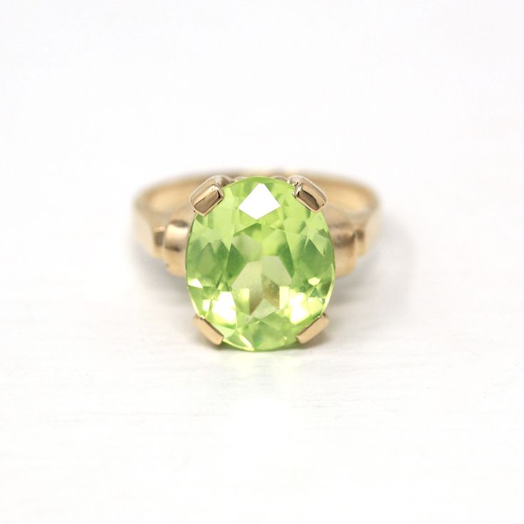 "Beautiful vintage circa 1940s era 10k yellow gold created green spinel ring! This lovely statement ring features an eye catching bright green 5.84 carat oval faceted created spinel, that is securely prong set. There are classic designs on the shoulders, and the shank is free of design. A wonderful 1940s era ring, featuring a pretty green stone!  ERA - Circa 1940s - Retro METAL / MATERIAL - 10k yellow gold, created spinel (approx. 5.84 CT) (Created spinel contains essentially the same chemical c Vintage 14k Gold Emerald Ring With Center Stone, Estate Style Oval Yellow Gold Rings, Yellow Gold Oval Estate Rings, Antique Oval Rings For May Birthstone, Antique Oval May Birthstone Rings, Oval Yellow Gold Estate Rings, Vintage Green Solitaire Ring, Vintage Green Solitaire Jewelry, Vintage Oval May Birthstone Jewelry