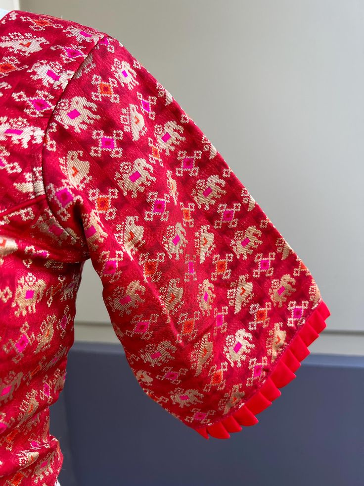 Red Color Blouse with Elephant and Peacock Motifs with Pink and Orange Meenakari Work and Zari Weaving. Comes with Cups attached to the blouse. Please note : Blouses has margin to open 2 sizes up. Item : Ready to Wear BlouseSize : 36 (Can opened to size- 40)Color : Red Blouse Fabric : Banarasi SilkBlouse Fitting : Princess Cut Lining : Yes, it is fully lined Padded or Non-Padded : Padded Closure: Back Closure with hooks.Ready-to-Wear : Yes Disclaimer -This is a Standard Size blouse. We do not gu Peacock Motifs, Men's Ethnic Wear, Color Blouse, Bandhani Saree, Red Blouse, Kanjivaram Sarees, Readymade Blouse, Cotton Pyjamas, Banarasi Sarees