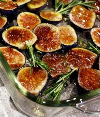 sliced figs in a baking dish with rosemary