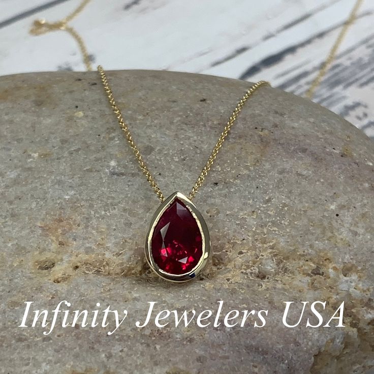 "The pendant pictured is a lab created red ruby #6930 -Approximate total carat weight: approx. 2.00ctw diamond equivalent -Center Stone Size: 10x7mm - approx. 2.00ct diamond equivalent -Center Stone Shape: pear -Gem Type: lab created ruby -Stone Clarity: AAA -Stone Color: Red -Moh's Scale: 9 hardness -Metal Type and Purity: 14k yellow gold -Setting: bezel set -Chain: delicate 14k gold chain / heavier option with lobster claw available (use dropdown to select) -Country of Manufacturing: USA (Mich Pear-shaped Ruby Jewelry For Anniversary, Red Pendant Jewelry With Bezel Setting, Red Gemstone Pear-shaped Necklace, Red Pear-shaped Gemstone Necklace, Red Ruby Necklace With Bezel Setting, Pear-shaped Ruby Gemstone Necklace, Red Ruby Jewelry With Bezel Setting, Pear-shaped Ruby Necklace For Anniversary, Tear Drop Pendant