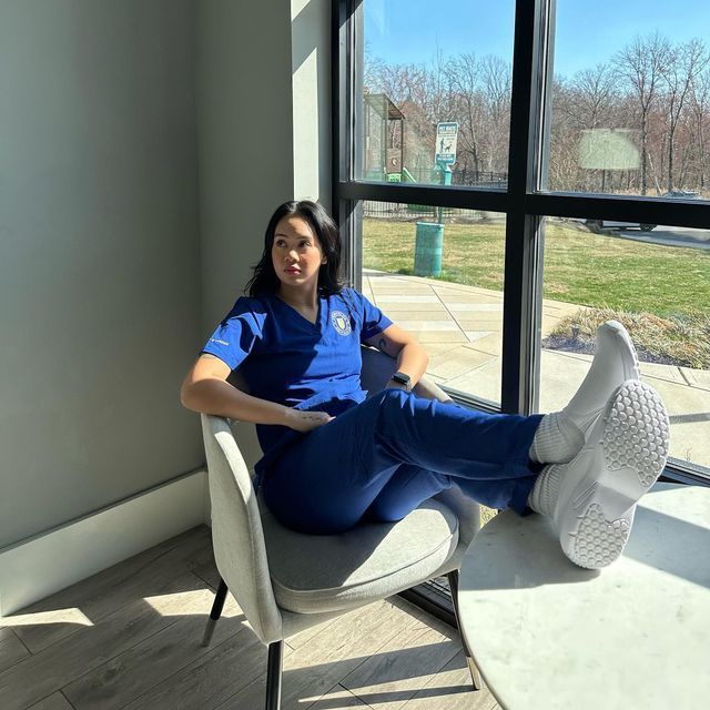 a woman sitting in a chair with her feet up on the table next to a window