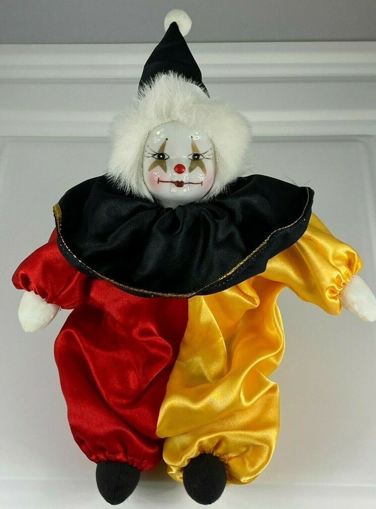 a clown doll is dressed in red, yellow and black