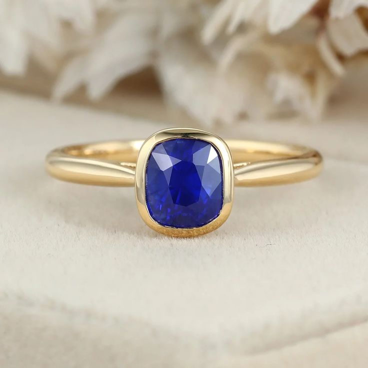 Indulge in luxury with our 14K Yellow Gold Cushion Cut Blue Sapphire Ring for Women. This captivating piece combines opulence and sophistication, featuring a mesmerizing blue sapphire gemstone elegantly set in lustrous yellow gold. Gold Sapphire Ring With Cushion Cut, Luxury Yellow Gold Sapphire Cushion Cut Ring, Gold Cushion Cut Sapphire Ring, Elegant Gold Sapphire Ring With Cushion Cut, Gold Cushion Cut Sapphire Ring Fine Jewelry, Yellow Gold Sapphire Ring With Cushion Cut, Cushion Cut Sapphire Ring In Yellow Gold, Luxury Gold Sapphire Cushion Cut Ring, Elegant Sapphire Ring With Tanzanite And Polished Finish