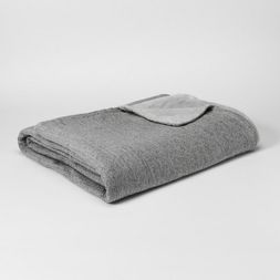 a gray blanket folded on top of a white table