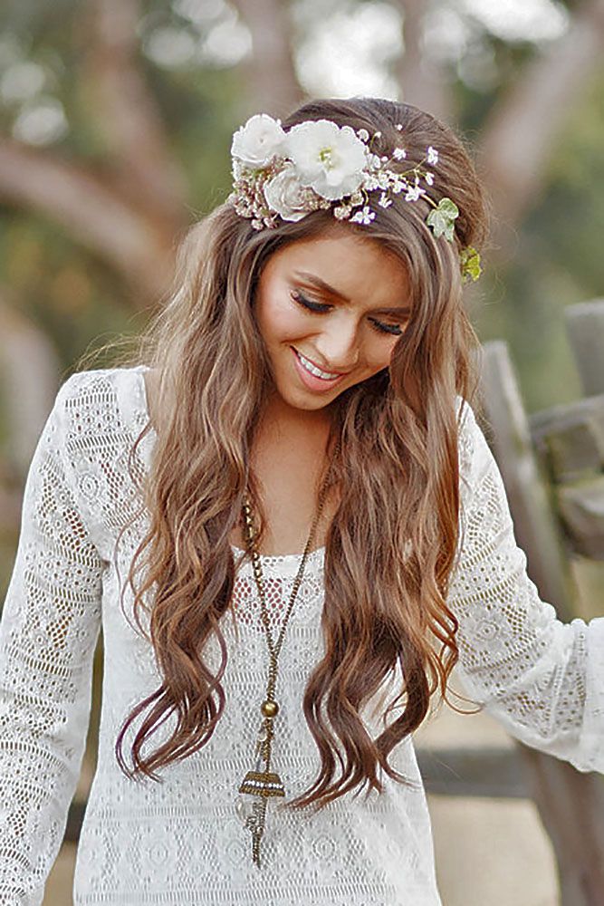 a woman with long hair wearing a flower crown on top of her head and white dress