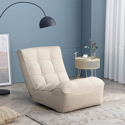 a living room with blue walls and a beige chair in the corner next to a table