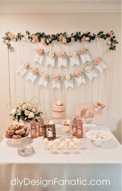 a table topped with cakes and cupcakes next to a wall hanging from the ceiling