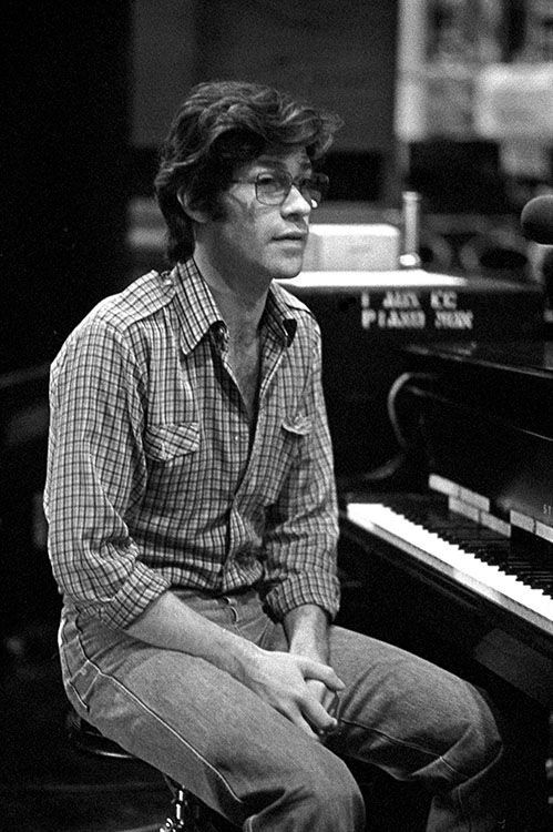 a man sitting in front of a piano