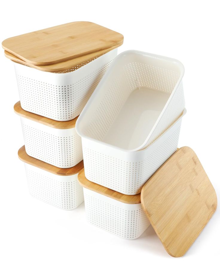 four white plastic containers with bamboo lids and chopping board on the top one is empty