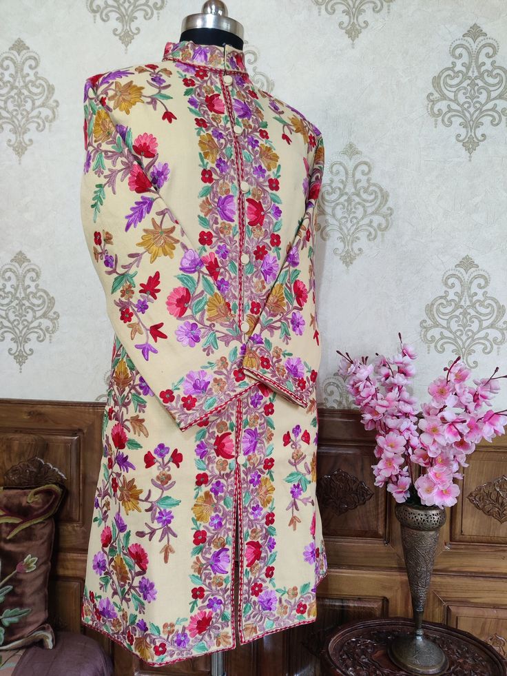 Kashmiri Jacket Women, Embroidery Jacket, Kashmiri Coat Get Customizable Kashmiri Jacket With Multi-colour Embroidery  A Long Woolen Kashmiri Jacket with All Over Multicolour Aari Embroidery (Front & Back) This Kashmiri jacket Makes you stand apart with its vivid colours and Floral embroidery, The base colour is Beige With  Multicolor Aari Embroidery is done all over the jacket, the material used is of high-quality Pure wool and the embroidery is done by brilliant Kashmiri artisans. Embroidery Designer Multicolor Nehru Jacket With Chikankari Embroidery, Festive Multicolor Nehru Jacket With Chikankari Embroidery, Designer Multicolor Bandhgala With Chikankari Embroidery, Fitted Bollywood Nehru Jacket With Multicolor Embroidery, Bollywood Sherwani With Multicolor Resham Embroidery, Fitted Bollywood Sherwani With Multicolor Embroidery, Bollywood Style Fitted Sherwani With Multicolor Embroidery, Designer Traditional Wear With Resham Embroidery And Stand Collar, Unstitched Multicolor Embroidered Sherwani