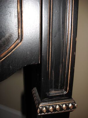 an old black clock with gold trim on it's face and back side, in a room