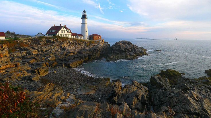 a lighthouse on top of a cliff next to the ocean