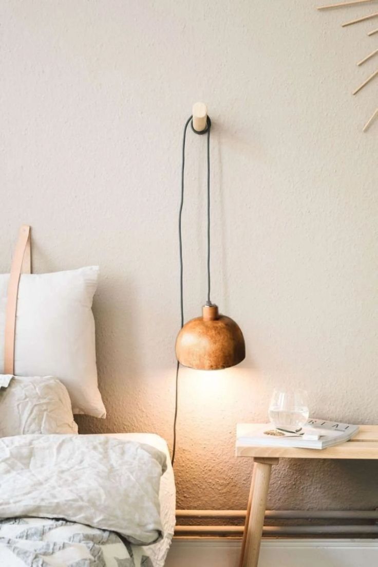 a bed room with a neatly made bed next to a night stand and a lamp