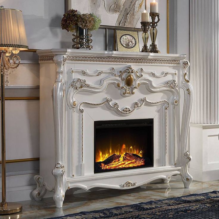 a white fireplace with a fire in the middle and candles on it's side