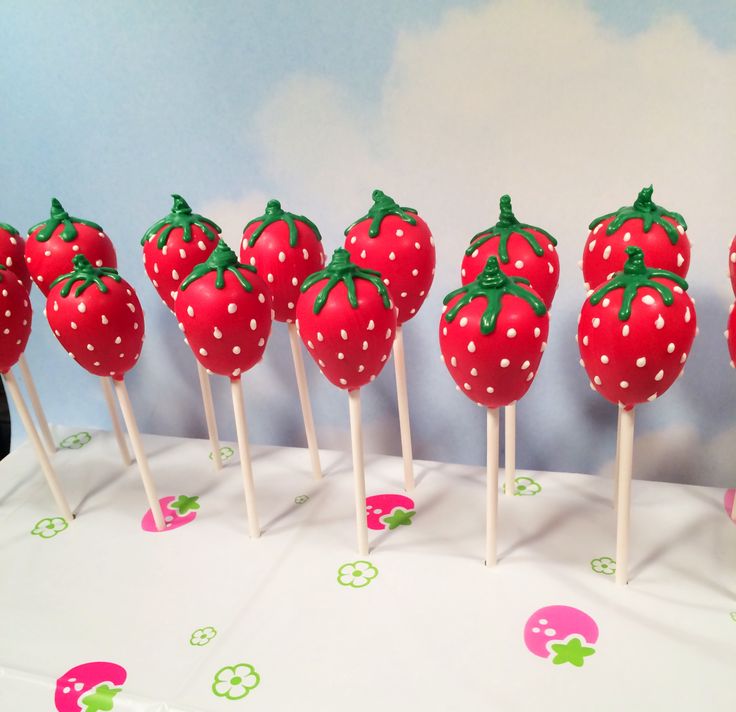 there are strawberries on the stick with green leaves and polka dot dots around them