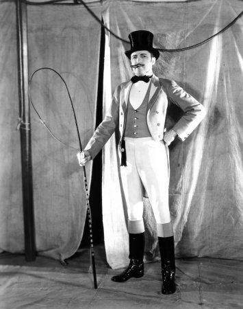 an old black and white photo of a man in a top hat, suit and cane