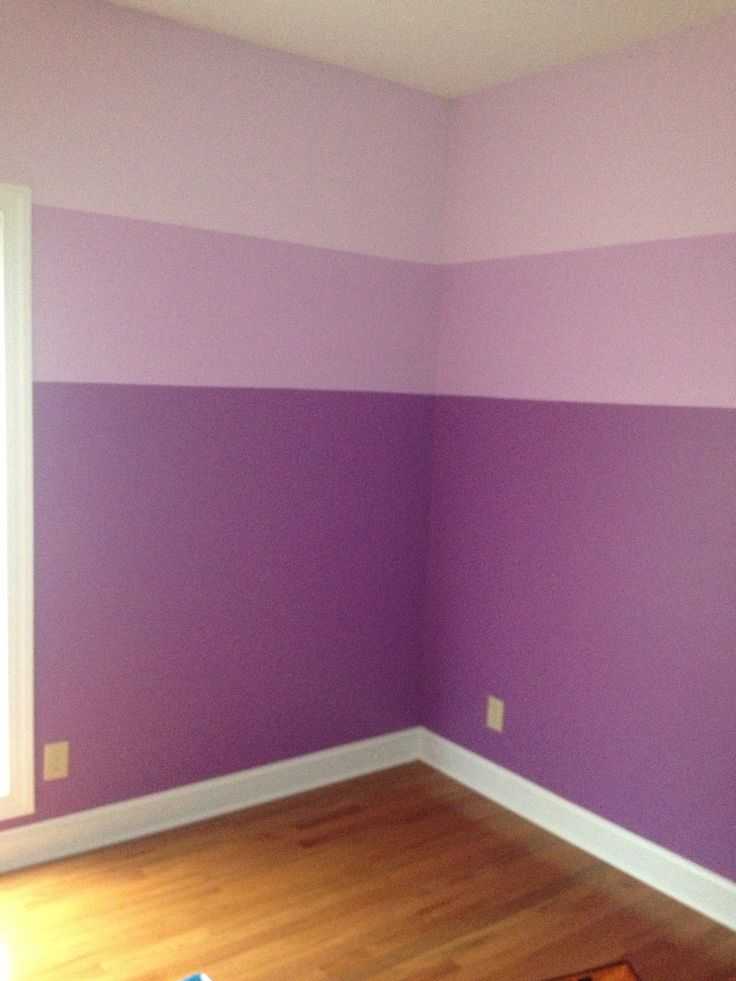 an empty room with purple walls and wood floors