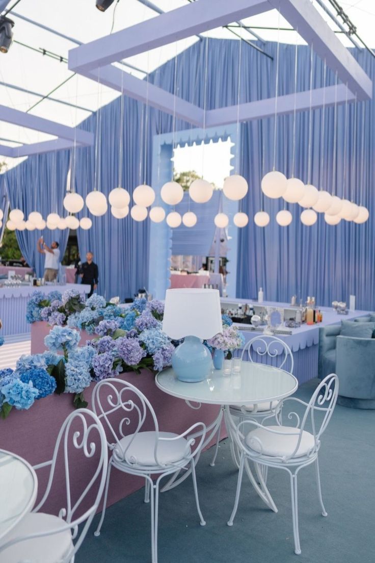 a table and chairs in a room with blue curtains