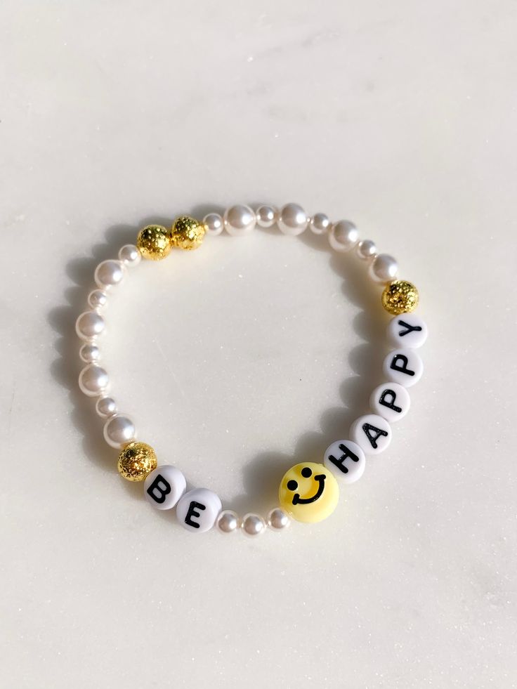 A smiley face and pearls...can't go wrong! Stack it with others or wear it alone and this bracelet will make you smile every time you look at it. stretchy one size made locally! All accessories are final sale. Be Happy Bracelet, Friendship Bracelets Smiley Face, Cheap Yellow Beaded Bracelet With Smiley Face, Bracelet With Words Ideas, Smile Face Bracelet, Beaded Bracelets Cute, Trendy Everyday Bracelet With Smiley Face, Trendy Everyday Bracelets With Smiley Face, Trendy Everyday Smiley Face Bracelet