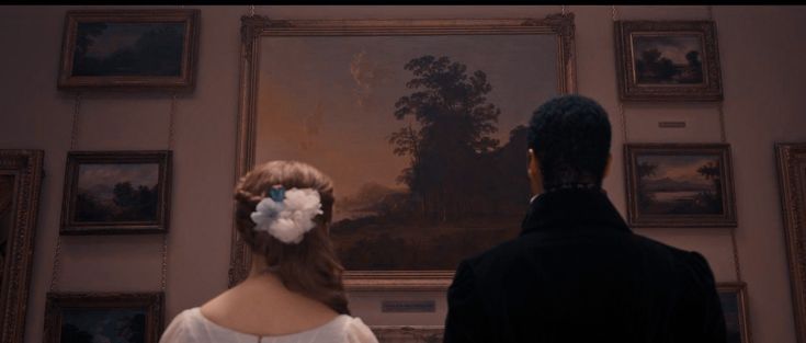 a man and woman standing in front of a painting