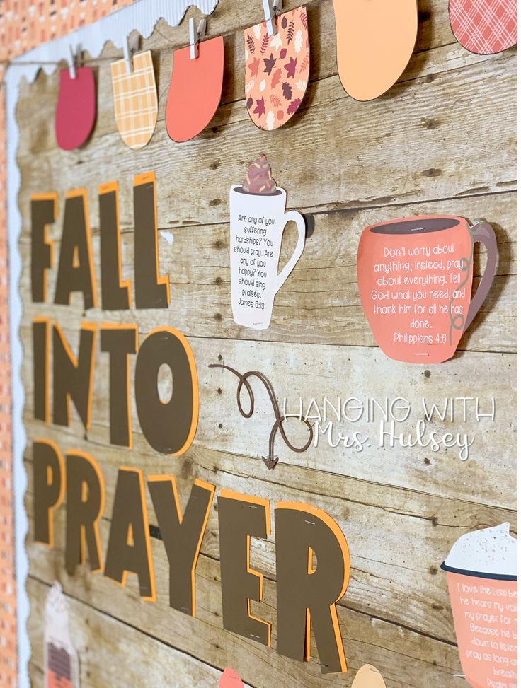 a wooden sign with paper cutouts on it that says fall into prayer and coffee mugs