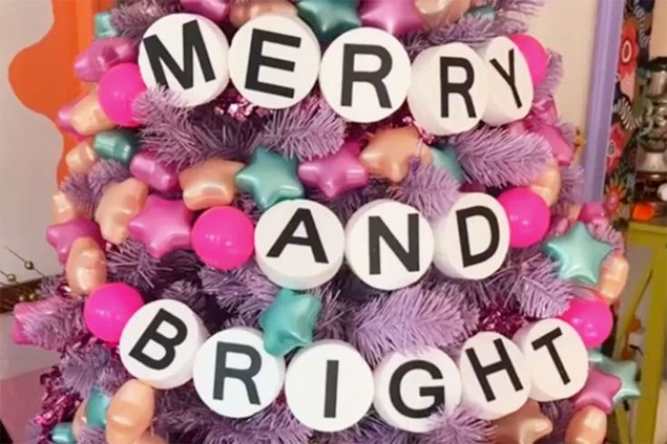 a christmas tree decorated with balloons and letters that say merry and bright on it's top