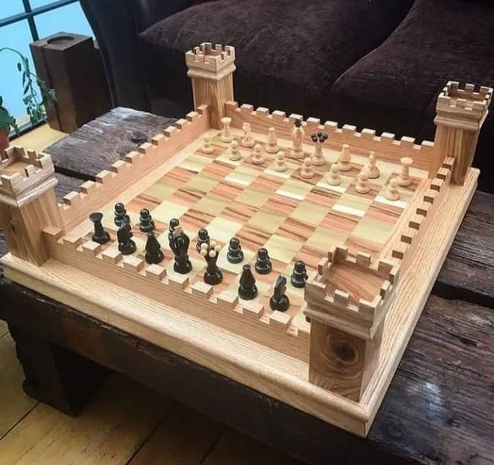 a wooden chess set sitting on top of a table in front of a couch and window