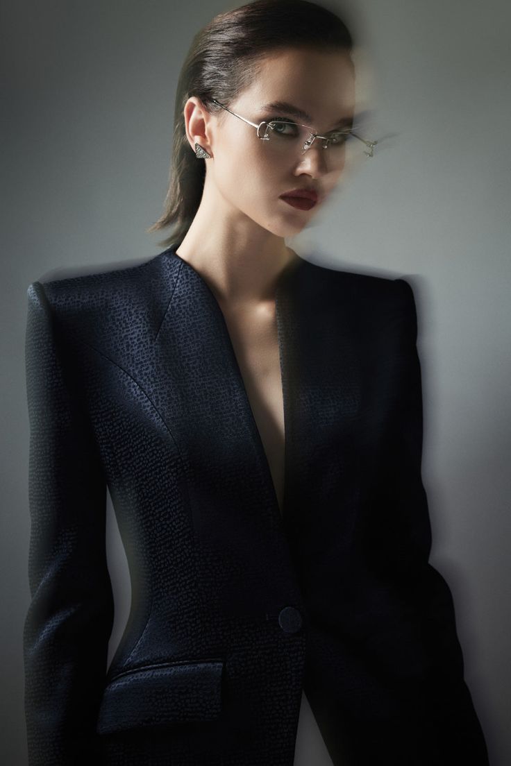 a woman wearing glasses and a black suit