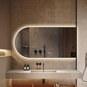 a bathroom with a sink, mirror and shower head mounted to the side of the wall