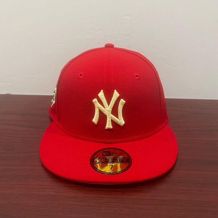 the new york yankees hat is on display in front of a white wall and wooden table