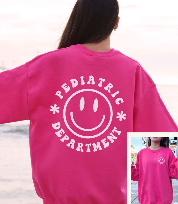 the back of a woman's pink sweatshirt with an image of a smiley face on it