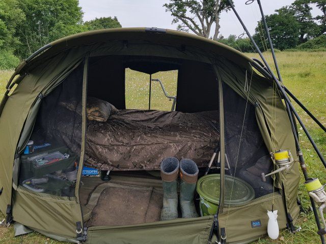 the inside of a tent with several items in it and trees in the back ground