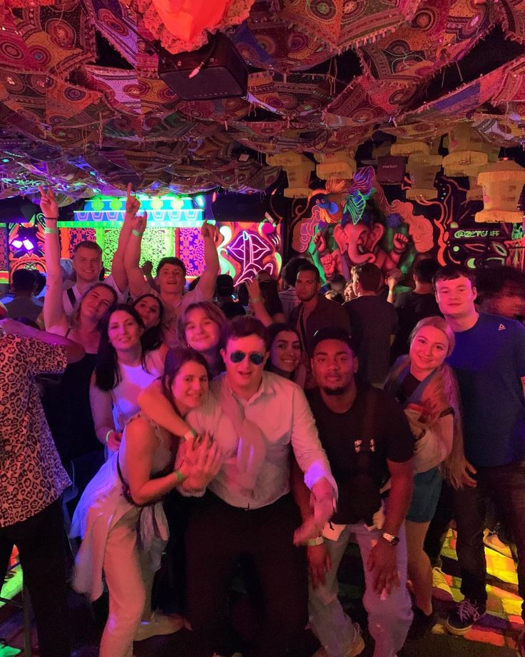 a group of people posing for a photo in a room with lights and decorations on the ceiling