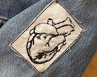 a patch on the back of a pair of jeans with an image of a human heart