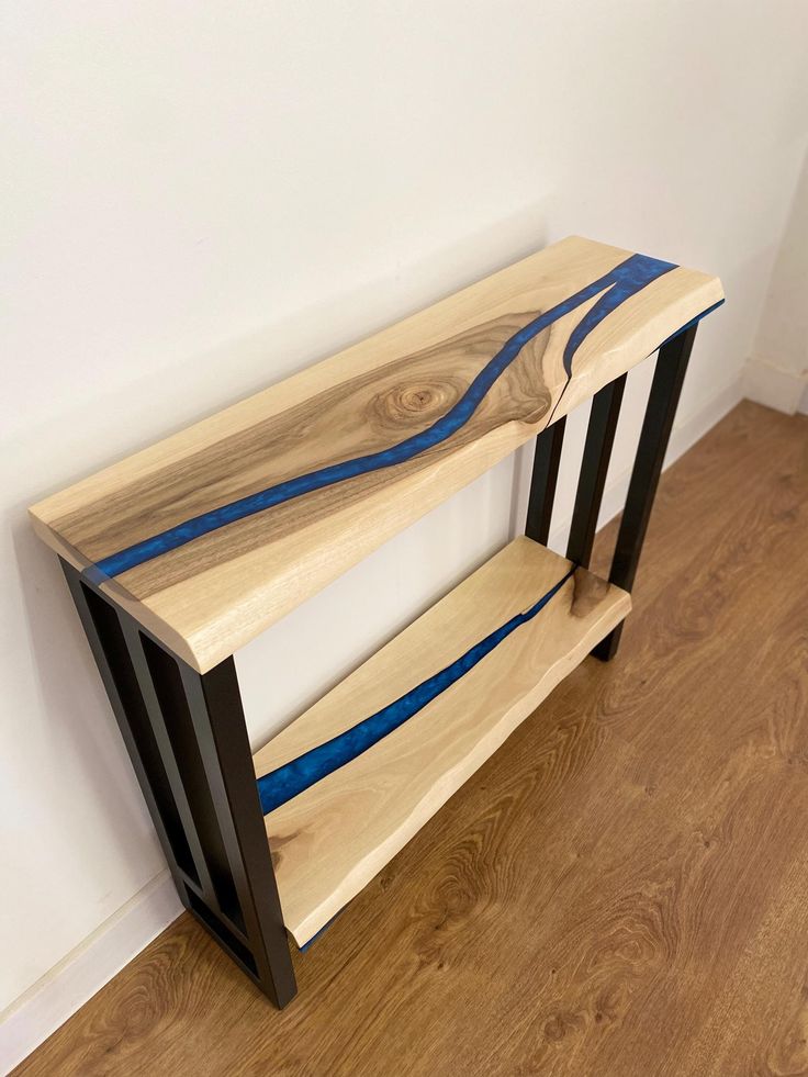 a wooden shelf sitting on top of a hard wood floor next to a white wall