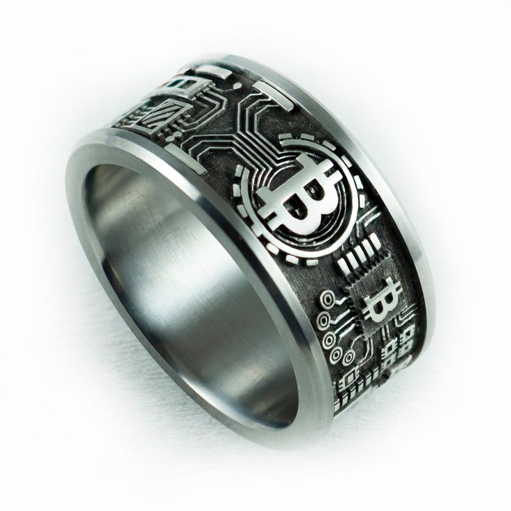 a silver ring with black and white designs on the inside, in front of a white background