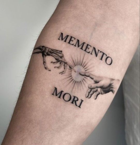 a man with a tattoo on his arm that says mementoo mor