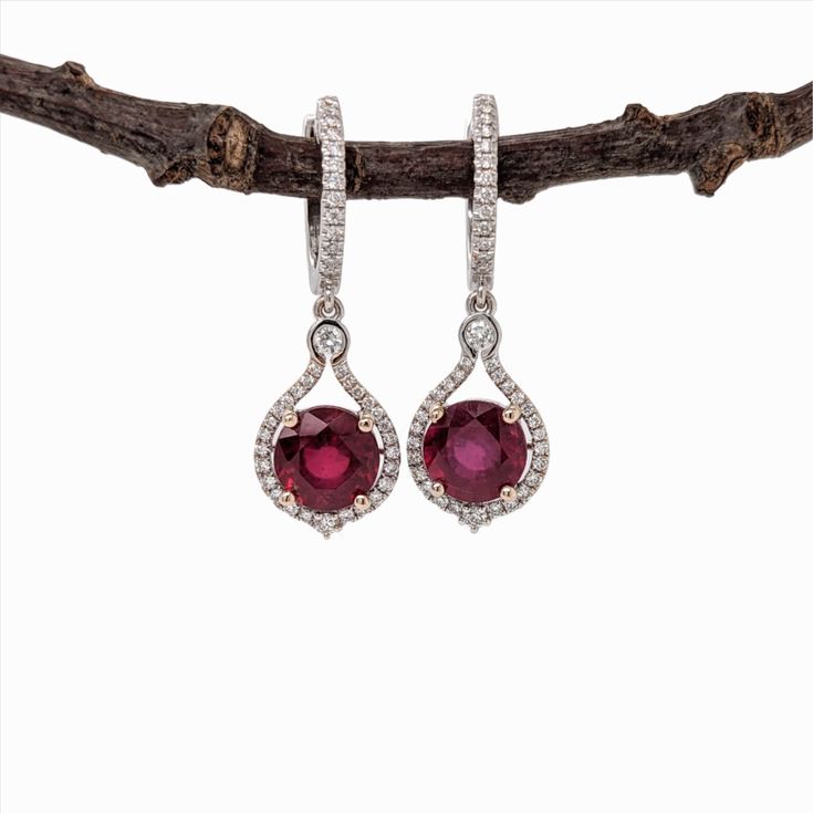 Beautiful Dangle Red Ruby Earrings in 14K Solid Gold w Natural Diamond Halo Accents | Round Shape 8mm | Secure Latch Back | July Birthstone Ruby Diamond Earrings With Brilliant Cut, Elegant Red Oval Diamond Earrings, Red Diamond Earrings In Fine Jewelry Style, Red Diamond Earrings Fine Jewelry, Fine Jewelry Red Diamond Earrings, Ruby Earrings With Prong Setting In Round Cut, Ruby Earrings With Brilliant Cut In Fine Jewelry Style, Ruby Brilliant Cut Fine Jewelry Earrings, Fine Jewelry Ruby Earrings With Brilliant Cut